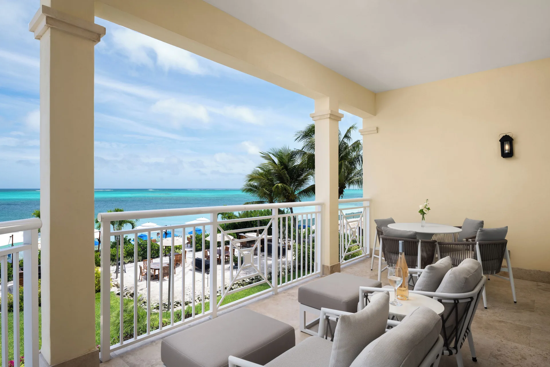 Oceanfront suite balcony with lounge seating and turquoise sea view at Windsong on the Reef.