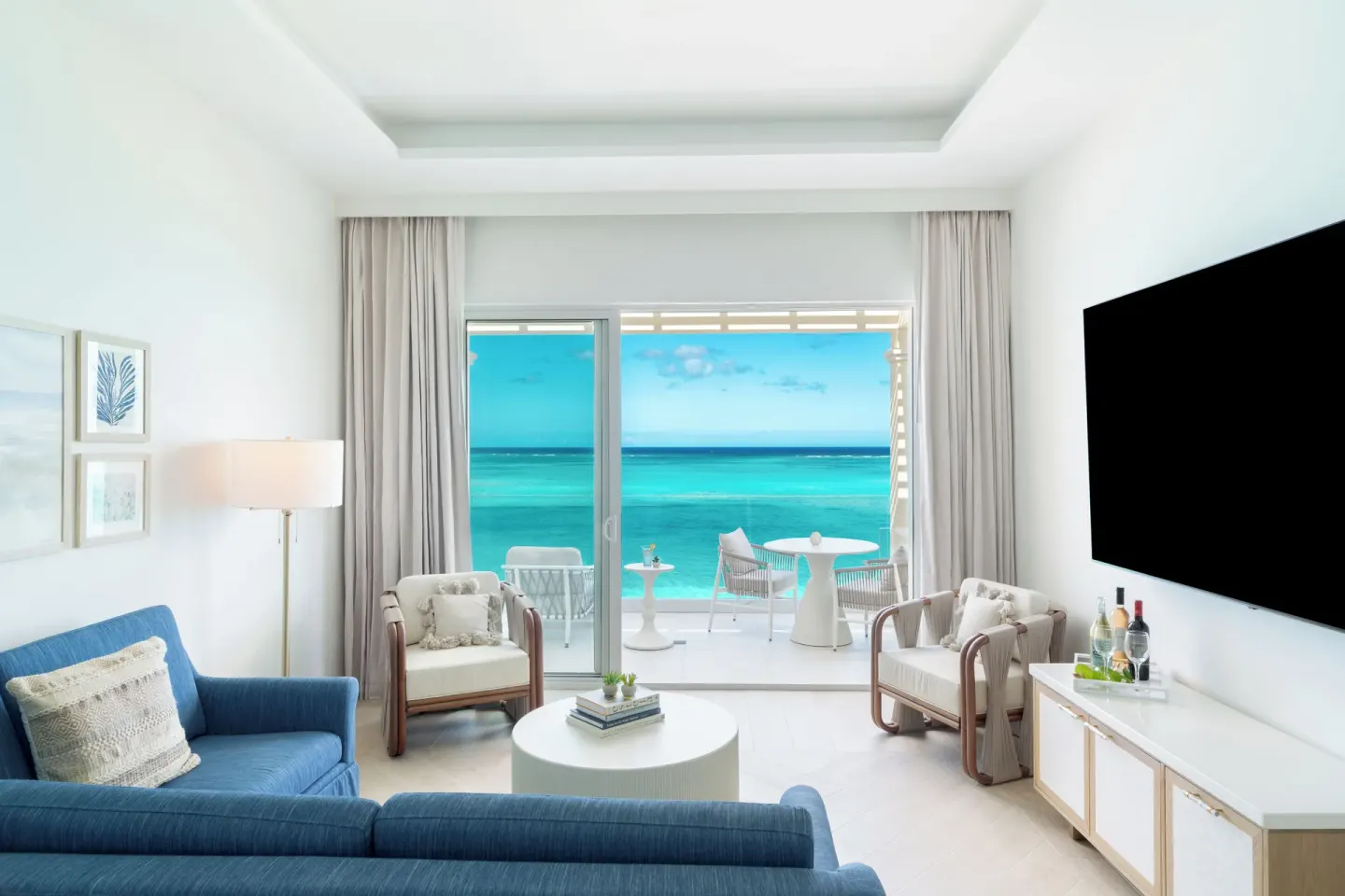 Beachfront villa living room with terrace seating and ocean view at Windsong on the Reef.