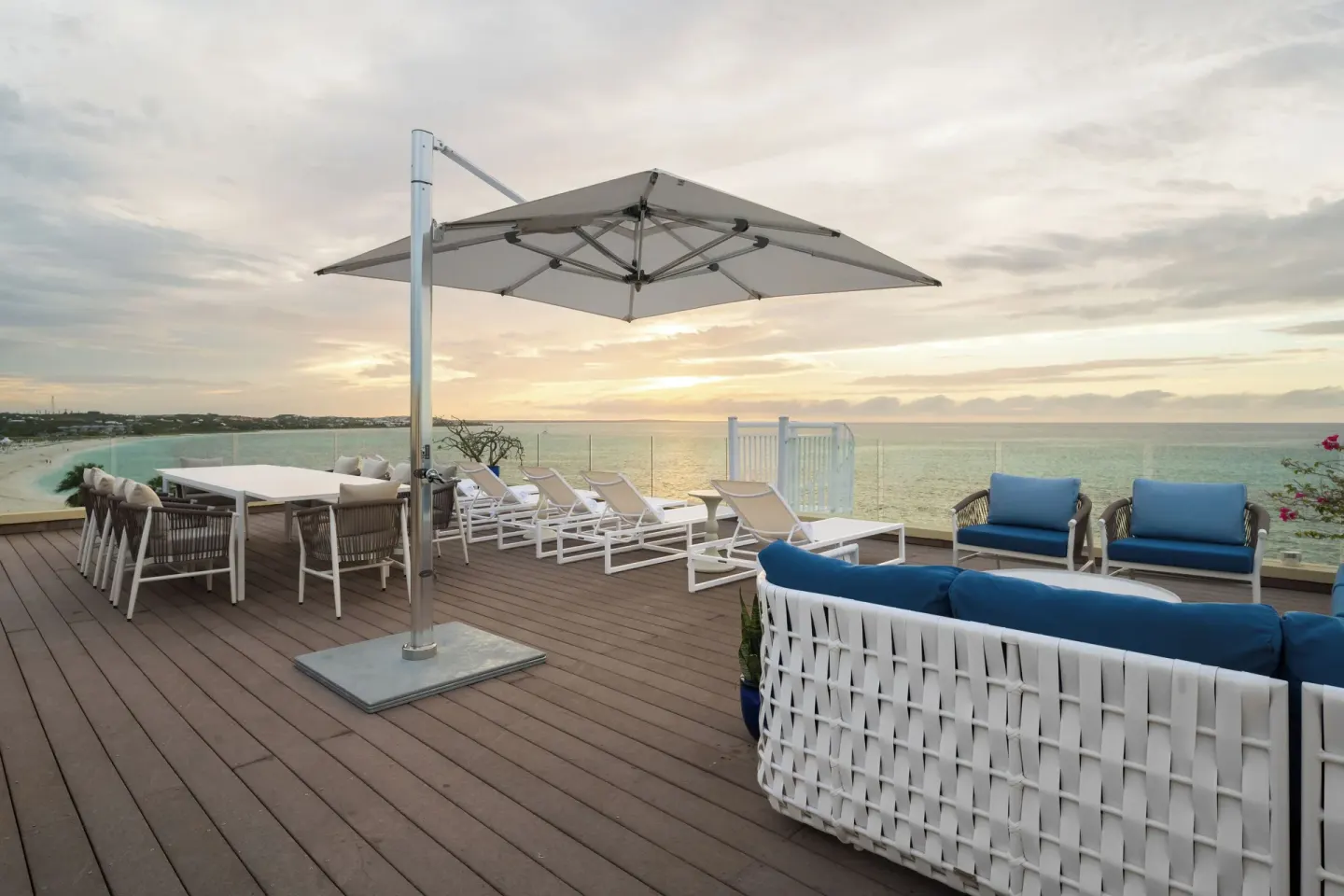 Oceanfront villa terrace lounge at Windsong on the Reef with umbrella and sea view.