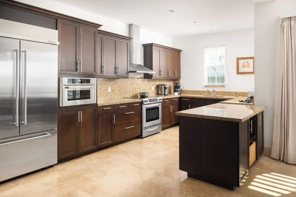Oceanfront villa kitchen with island and dark cabinetry at Windsong on the Reef.