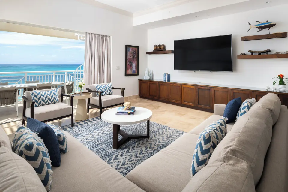 Oceanfront villa living room with terrace seating and sea view at Windsong on the Reef.