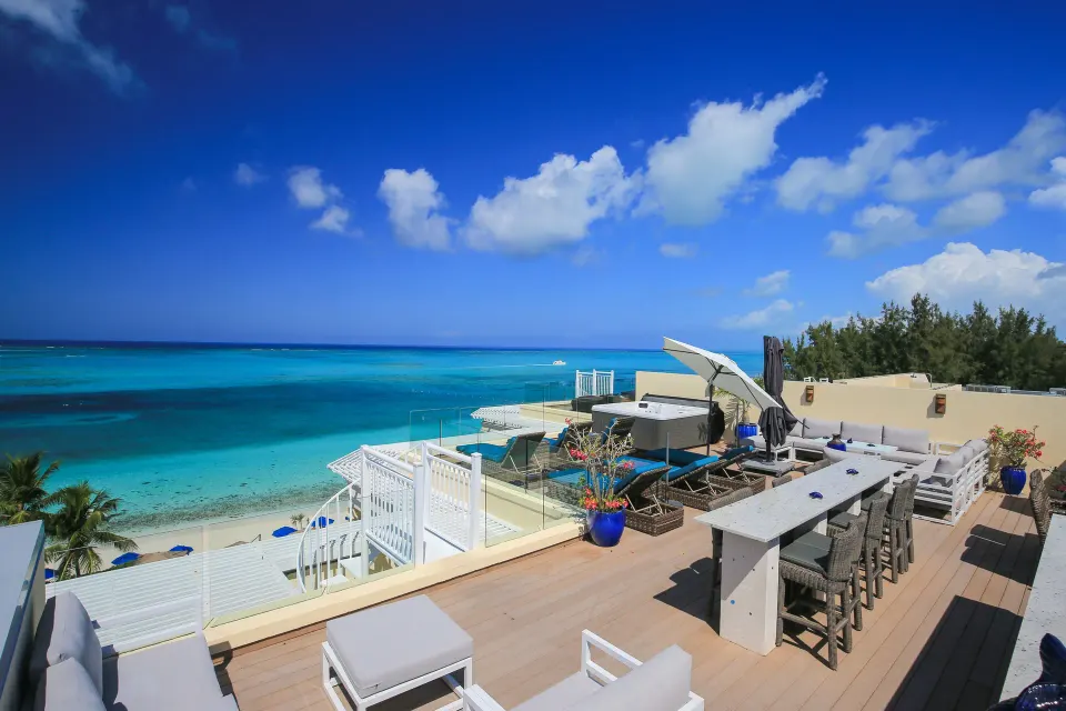 Oceanfront villa terrace with dining table and lounge seating at Windsong on the Reef.