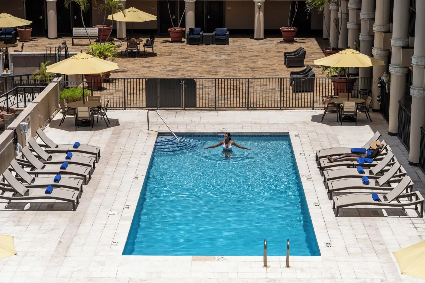 Centered view of the courtyard pool with loungers on both sides at Windward Passage Hotel.
