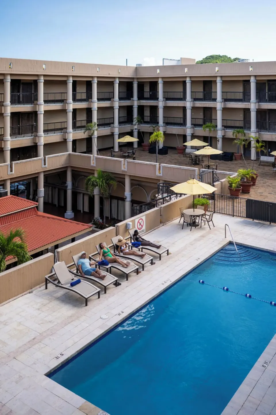 Guests relax by the courtyard pool at Windward Passage Hotel.