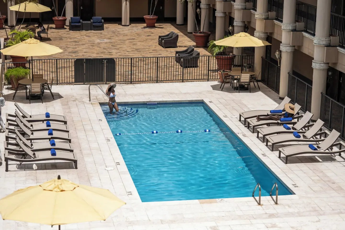 Courtyard pool with loungers and yellow umbrellas at Windward Passage Hotel.