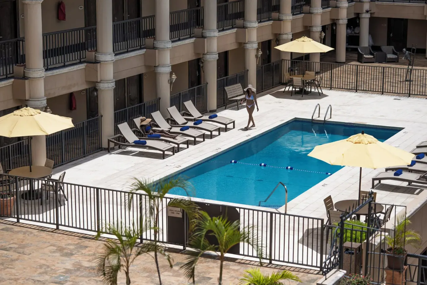 The courtyard pool has loungers, umbrellas, and a fenced deck at Windward Passage Hotel.