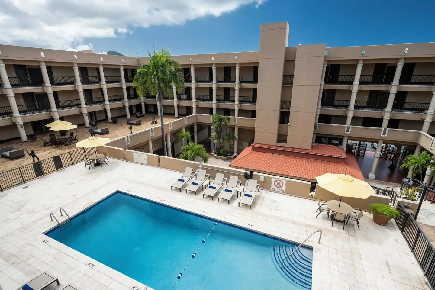 Outdoor pool with steps and courtyard seating at Windward Passage Hotel.