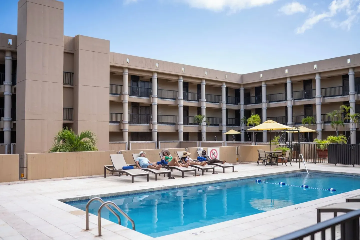 Pool deck with loungers and guest balconies at Windward Passage Hotel.