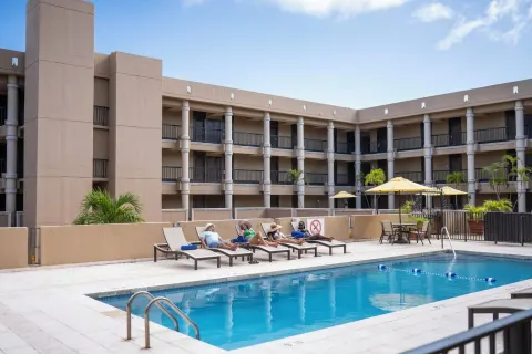 Pool deck with loungers and guest balconies at Windward Passage Hotel.