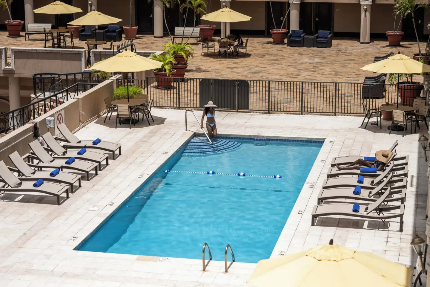 Pool deck with lounge chairs and shaded courtyard seating at Windward Passage Hotel.