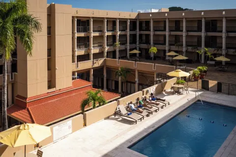 Pool deck with loungers, umbrellas, and balconies at Windward Passage Hotel.