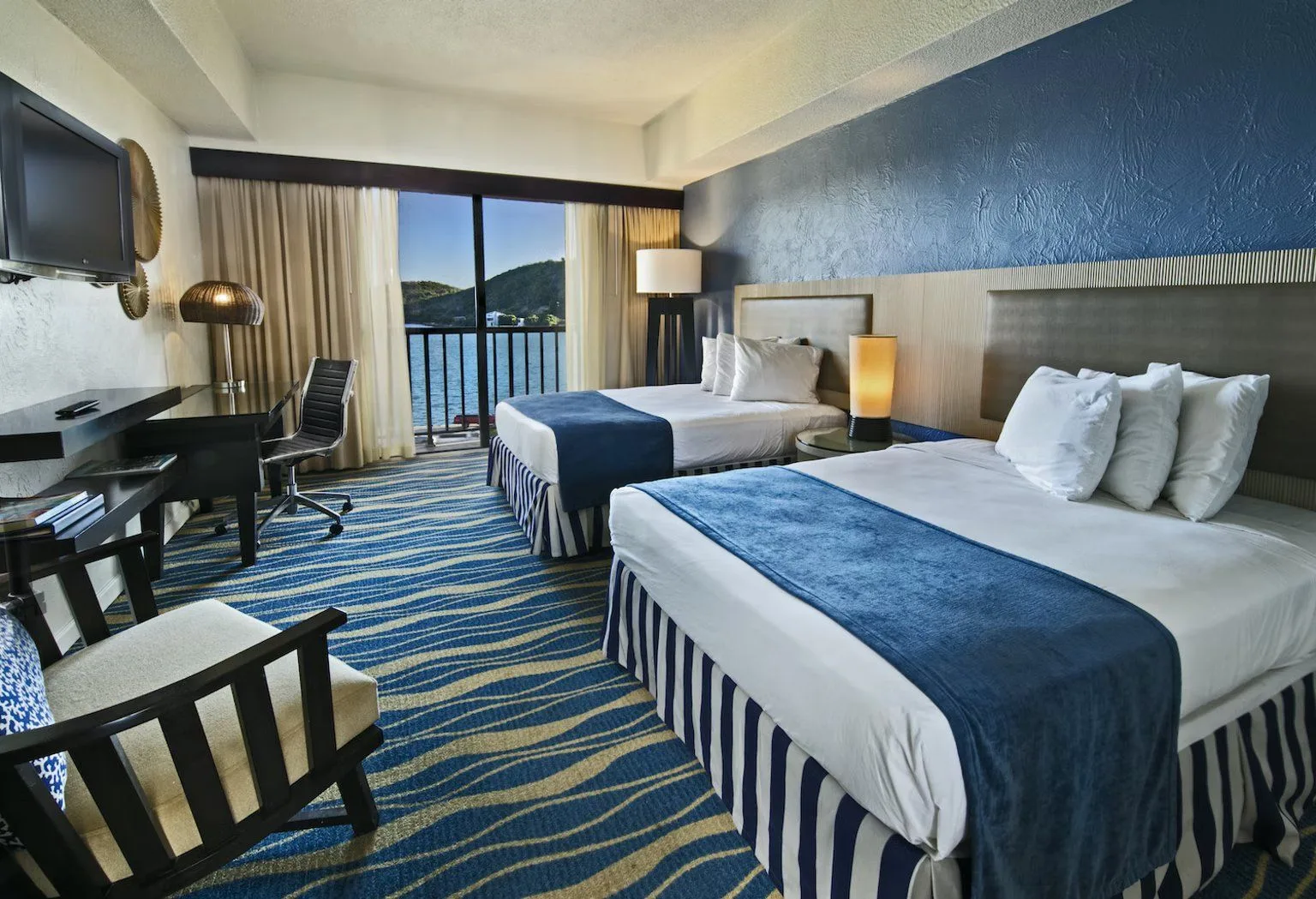 Ocean View Room with two beds and balcony water view at Windward Passage Hotel.
