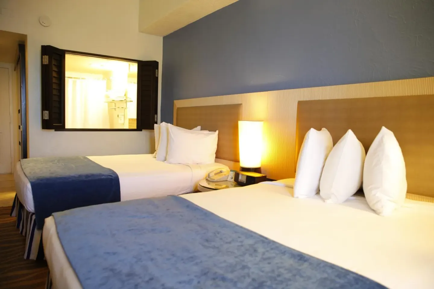 Standard Room with two beds and bathroom window at Windward Passage Hotel.