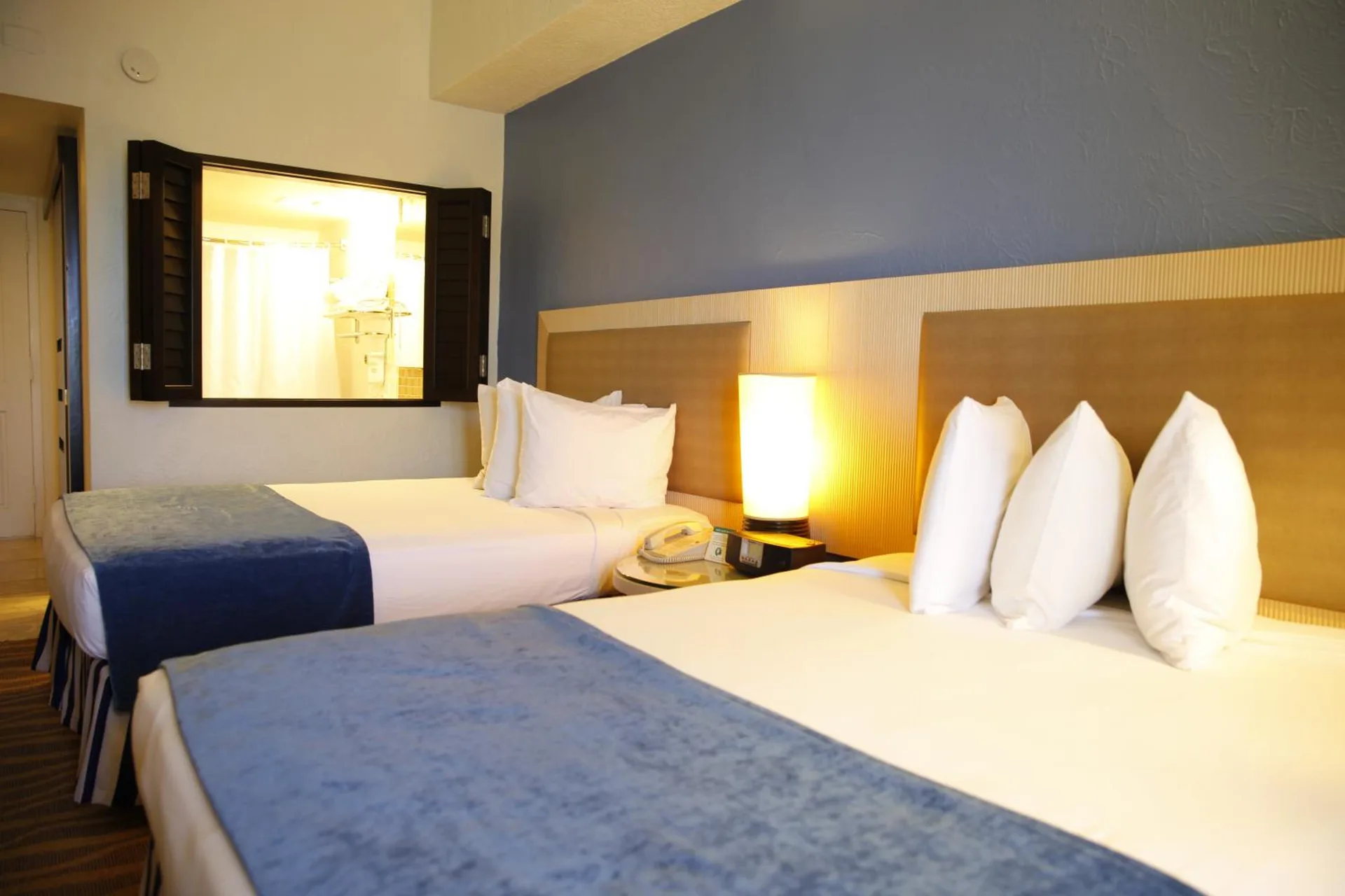 Standard Room with two beds and bathroom window at Windward Passage Hotel.