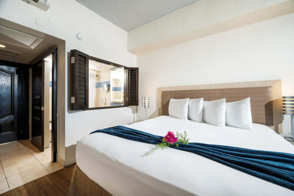 Superior Room Ocean View king bed near bathroom entrance at Windward Passage Hotel.