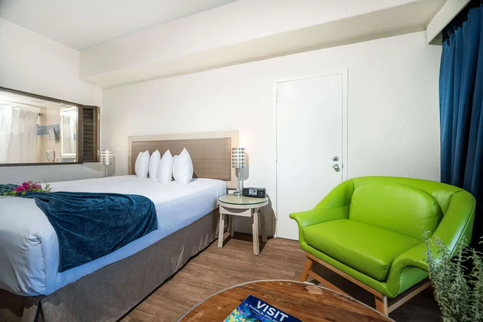 Superior Ocean View room with king bed and green armchair at Windward Passage Hotel.