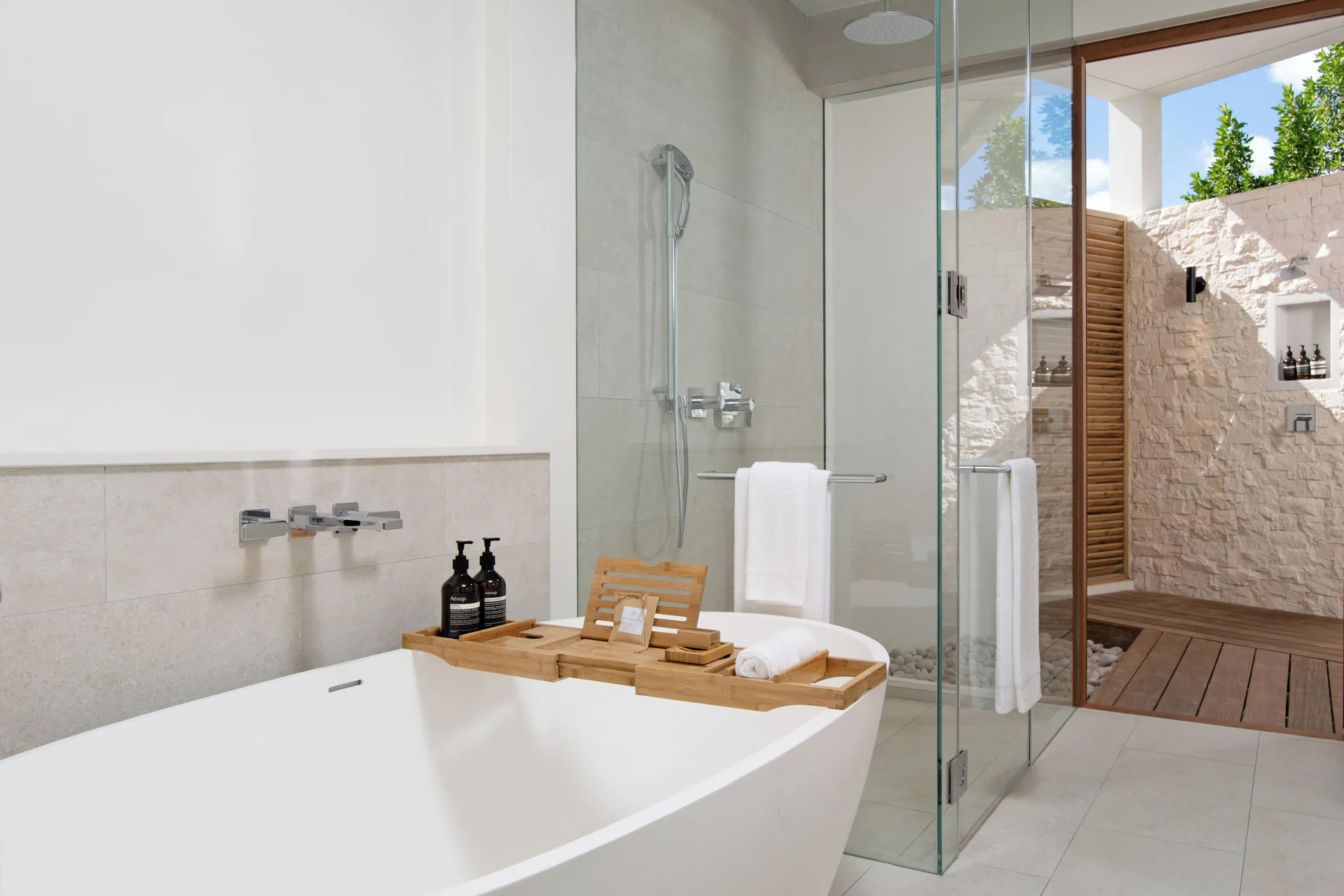Freestanding tub, glass shower, and outdoor shower area at Wymara Resort and Villas.