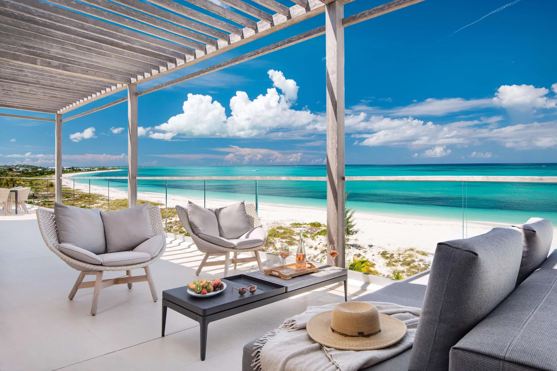 Beach-view terrace with lounge seating at Wymara Resort and Villas.