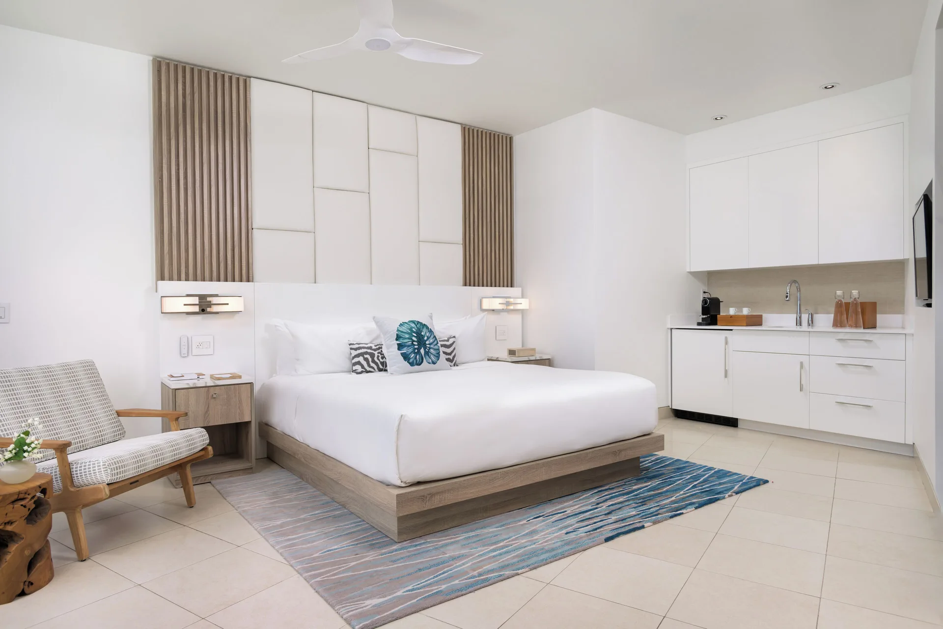 King guest room with kitchenette and lounge chair at Wymara Resort and Villas.