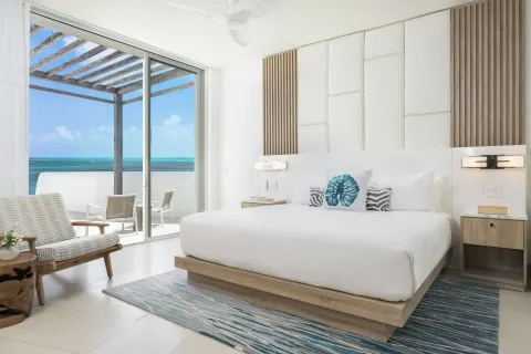 King bedroom with balcony and ocean view at Wymara Resort and Villas.