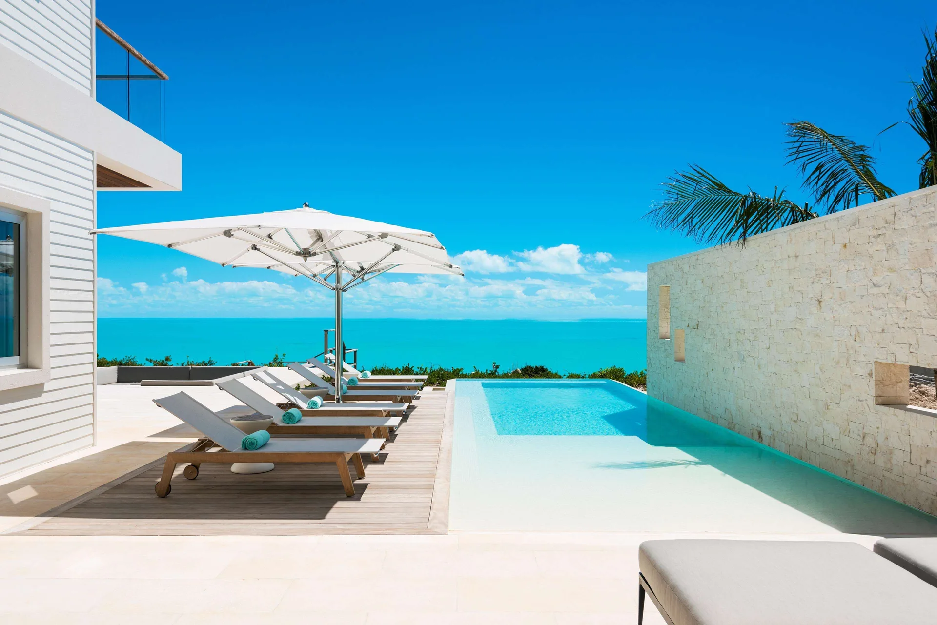 Ocean-view pool terrace with loungers at Wymara Resort and Villas.