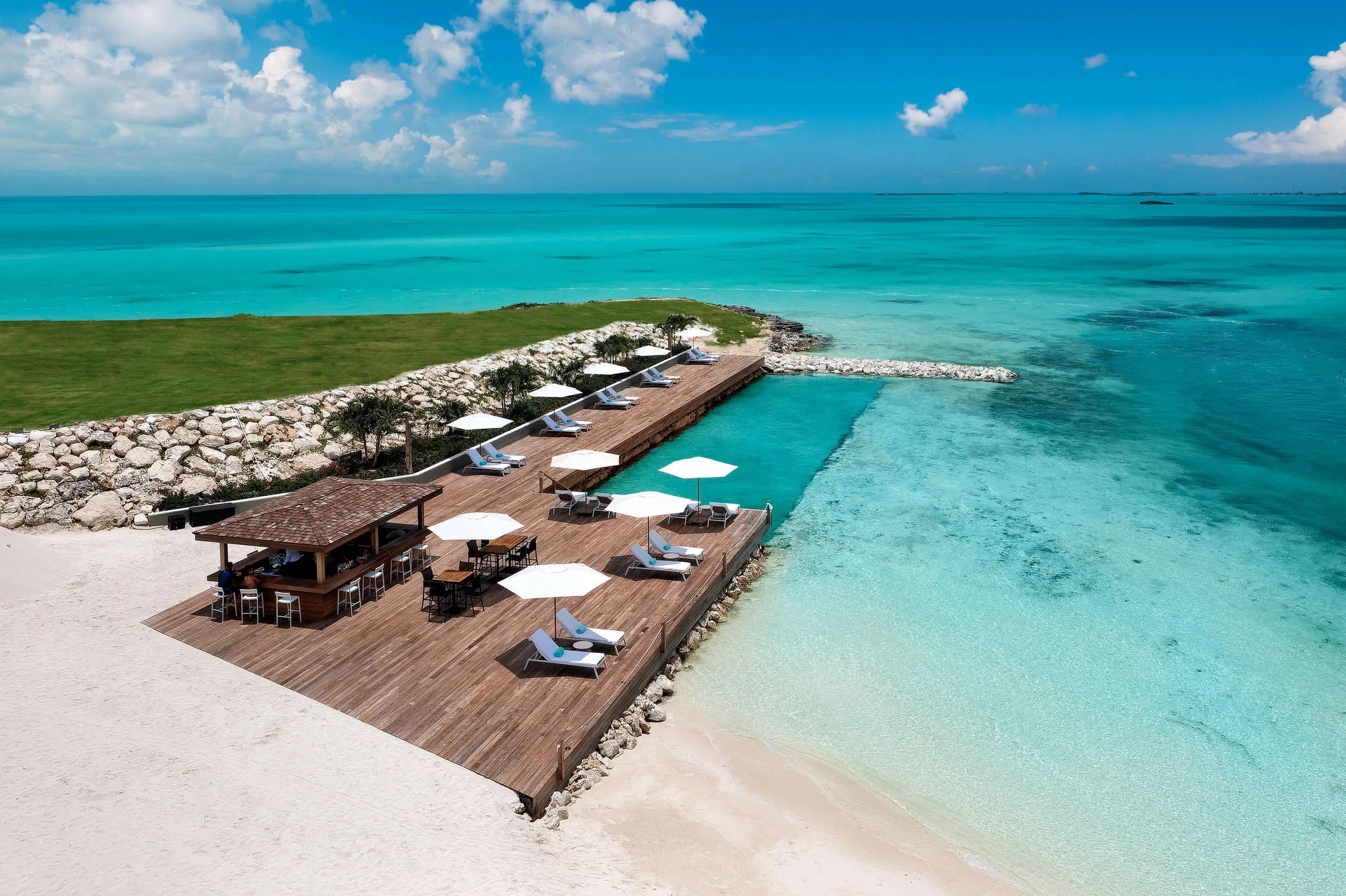Aerial view of a wooden ocean deck and turquoise water at Wymara Resort and Villas.