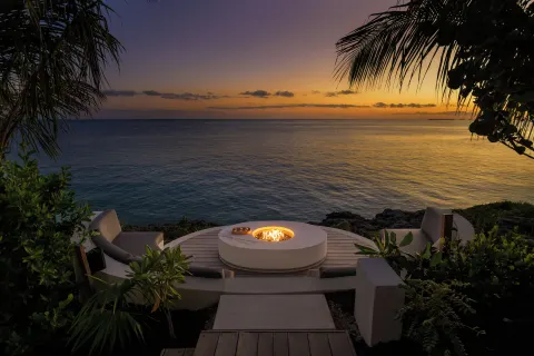 Oceanfront fire pit seating at sunset at Wymara Resort and Villas.
