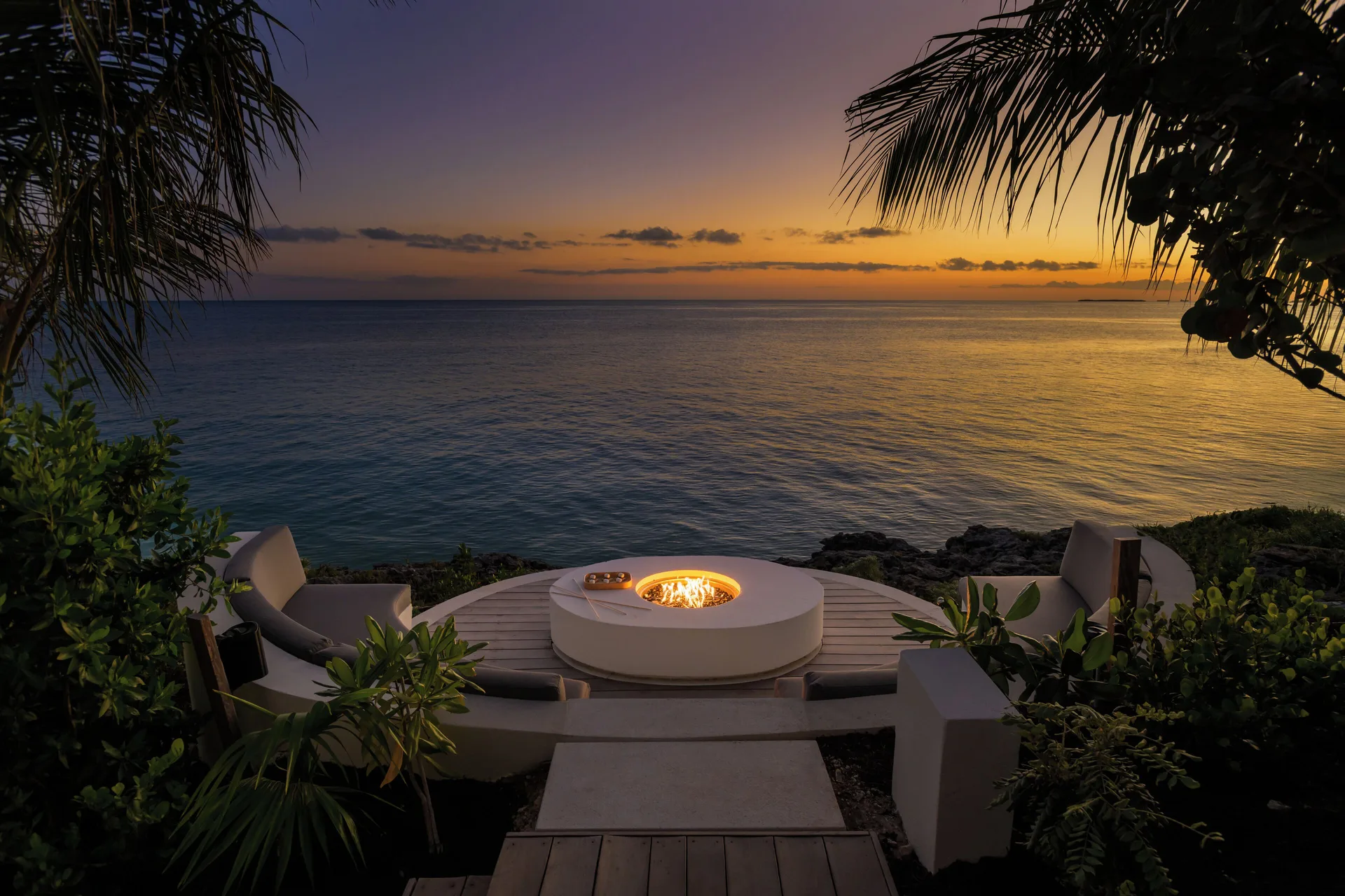 Oceanfront fire pit seating at sunset at Wymara Resort and Villas.