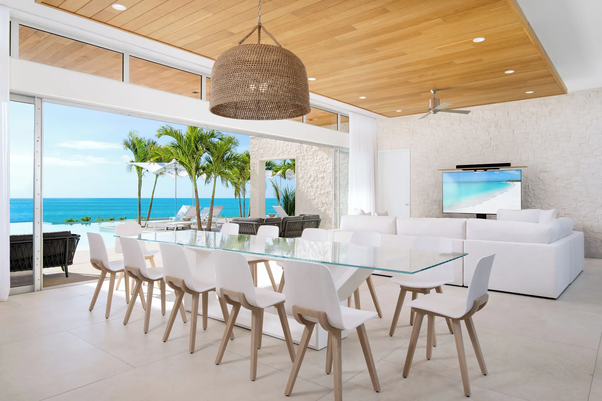 Glass dining table and ocean-facing living area at Wymara Resort and Villas.