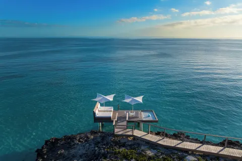 Overwater deck with white shade canopies at Wymara Resort and Villas.
