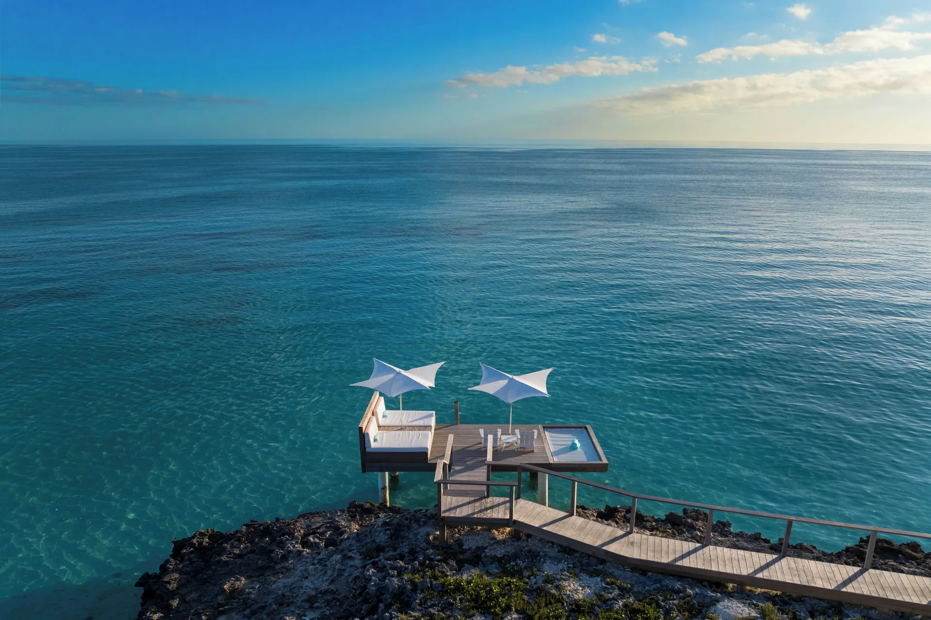 Overwater deck with white shade canopies at Wymara Resort and Villas.
