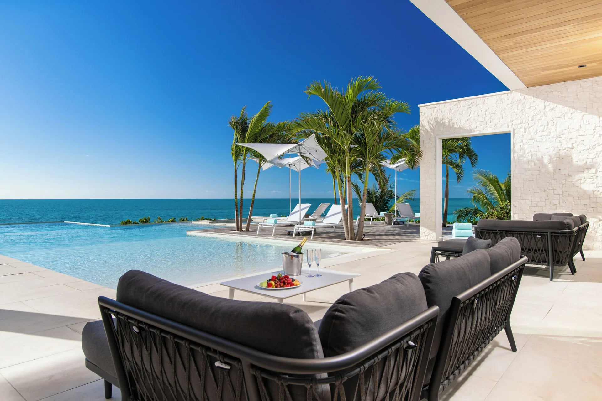 Poolside terrace seating with ocean view at Wymara Resort and Villas.