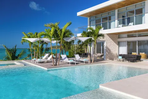 Villa pool deck with loungers and palms at Wymara Resort and Villas.