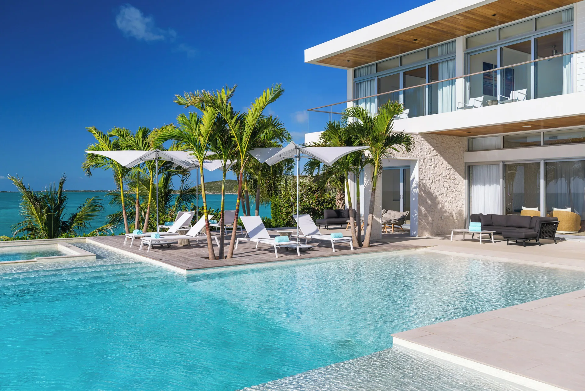 Villa pool deck with loungers and palms at Wymara Resort and Villas.