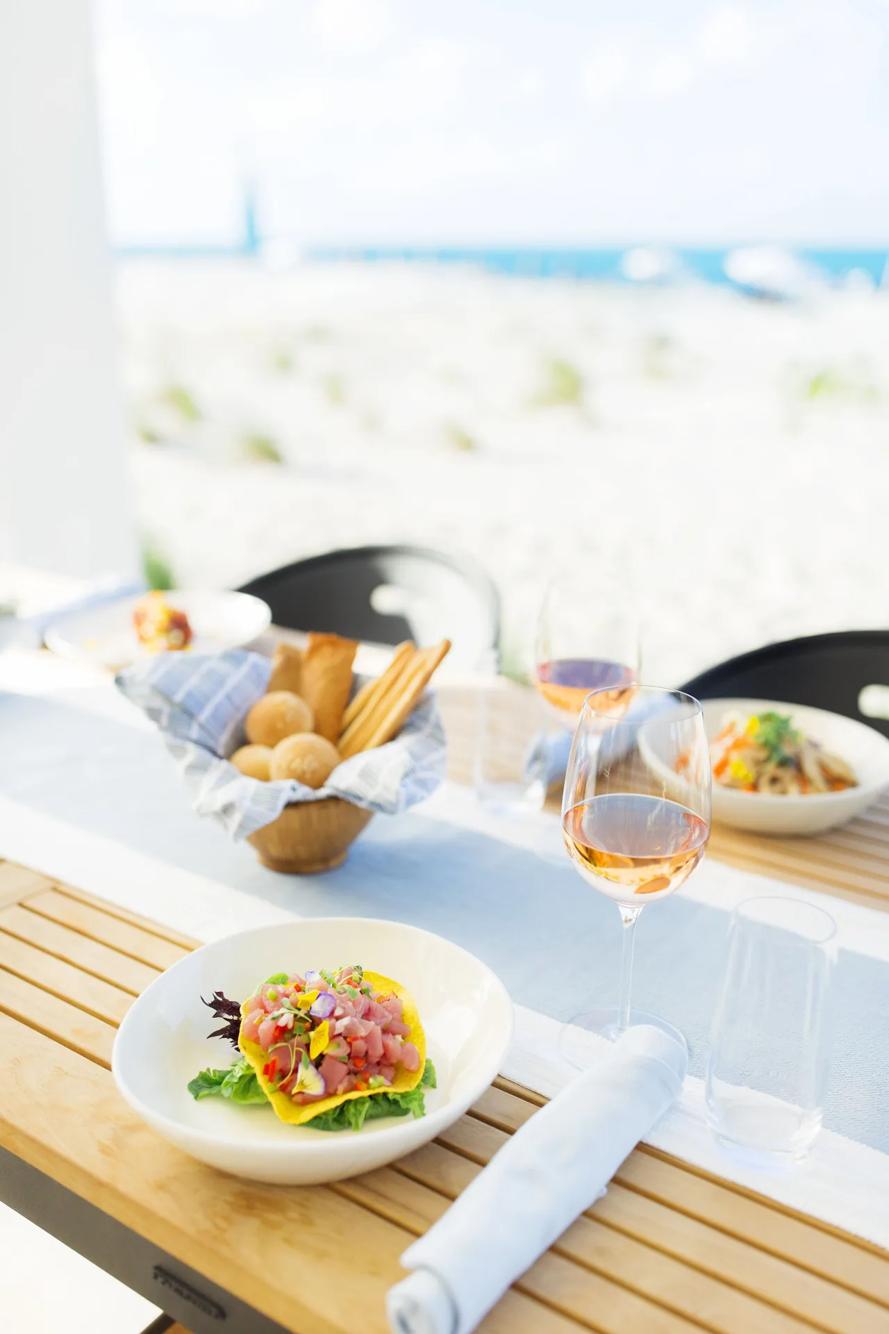 Beachfront lunch dishes and rosé wine at Wymara Resort and Villas.