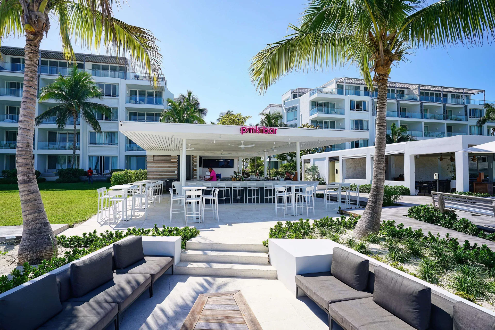 Pink Bar with outdoor seating and palm trees at Wymara Resort and Villas.