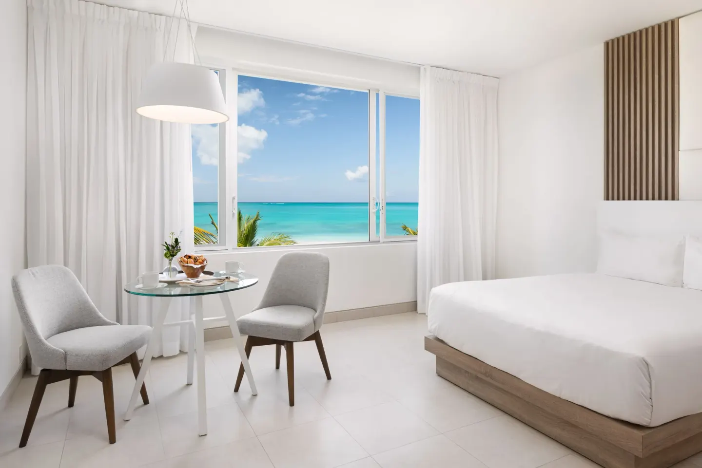 Grand Studio Oceanfront dining nook and king bed at Wymara Resort and Villas.
