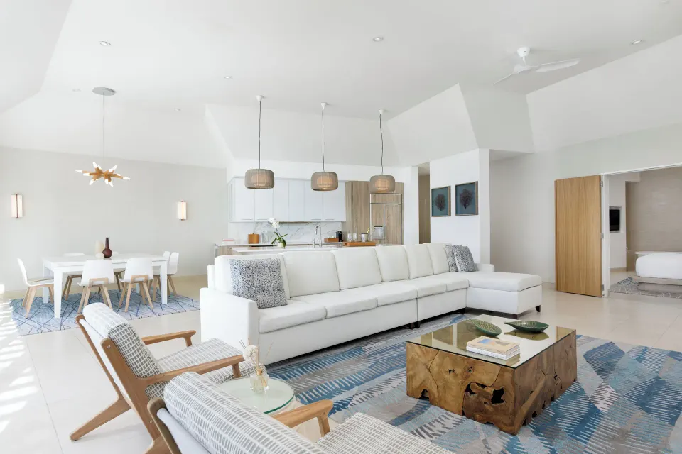 Penthouse one-bedroom suite lounge with sofa, dining table and kitchen at Wymara Resort and Villas.