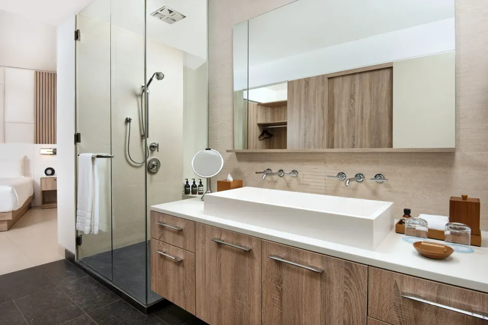 Oceanfront suite bathroom with double vanity and glass shower at Wymara Resort and Villas.