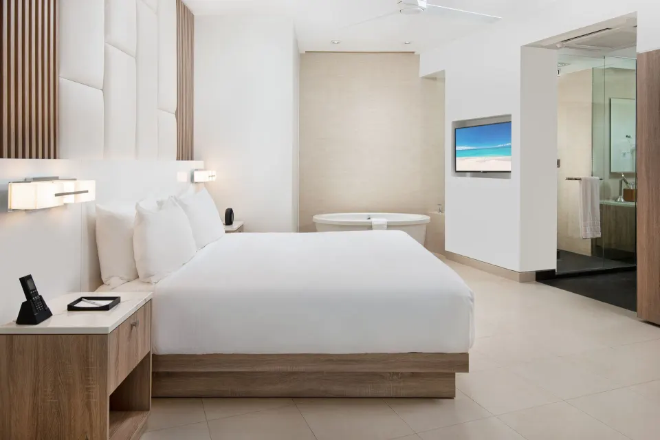 Oceanfront one-bedroom suite king bed and soaking tub at Wymara Resort and Villas.
