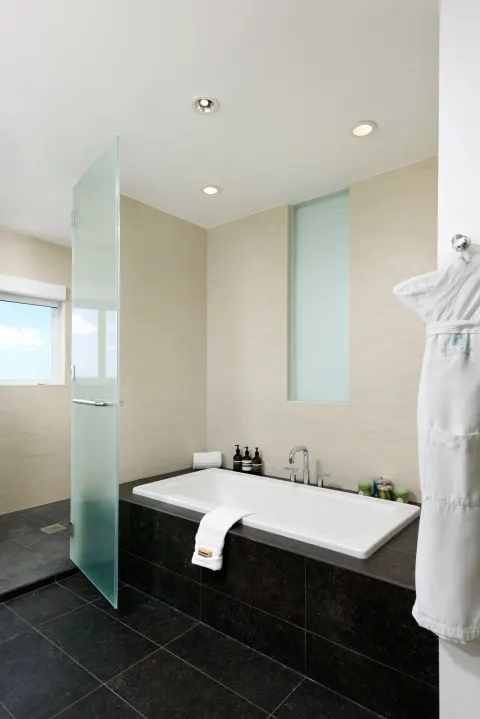 Oceanfront penthouse suite bathroom with soaking tub and shower at Wymara Resort and Villas.