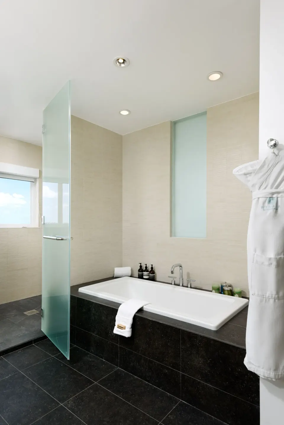 Oceanfront penthouse suite bathroom with soaking tub and shower at Wymara Resort and Villas.