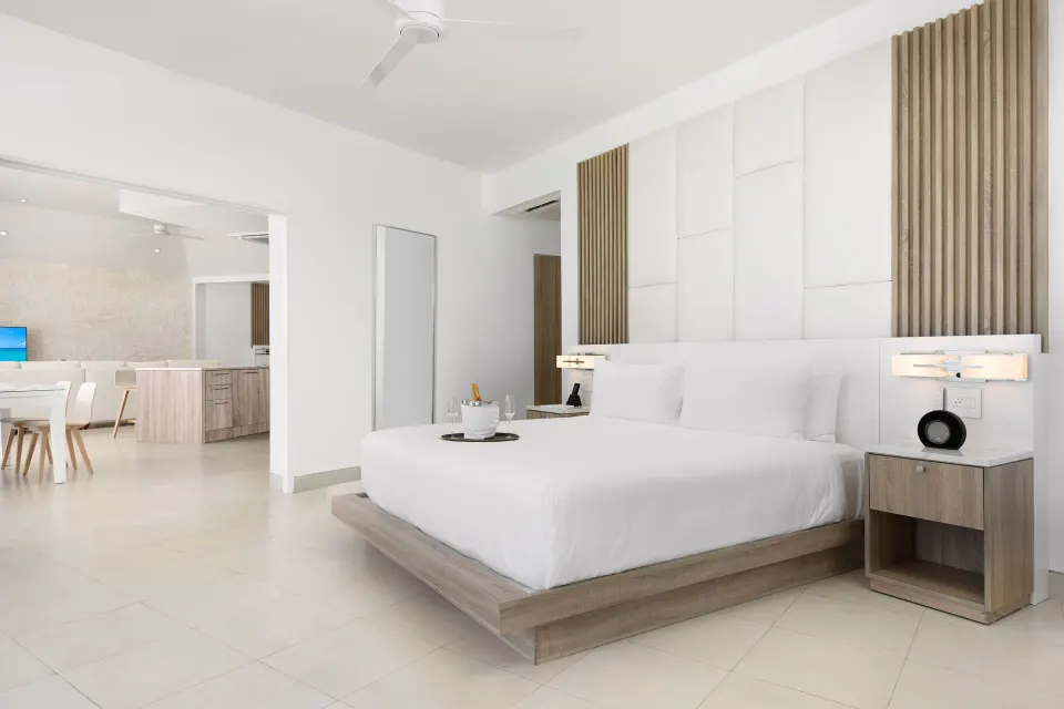 Oceanfront penthouse suite bedroom with open living area at Wymara Resort and Villas.