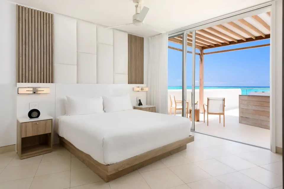 Oceanfront penthouse suite king bed facing a terrace at Wymara Resort and Villas.