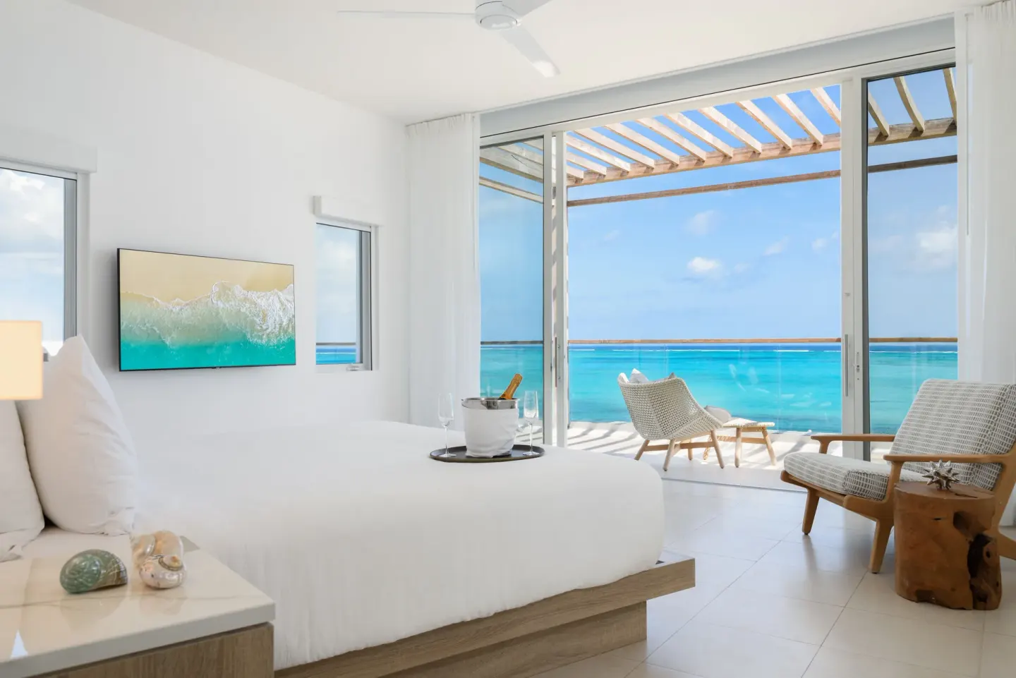 Oceanfront penthouse suite bedroom with terrace and turquoise water at Wymara Resort and Villas.