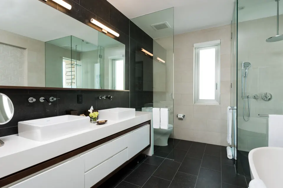 Villa bathroom with long vanity, shower, and tub at Wymara Resort and Villas.
