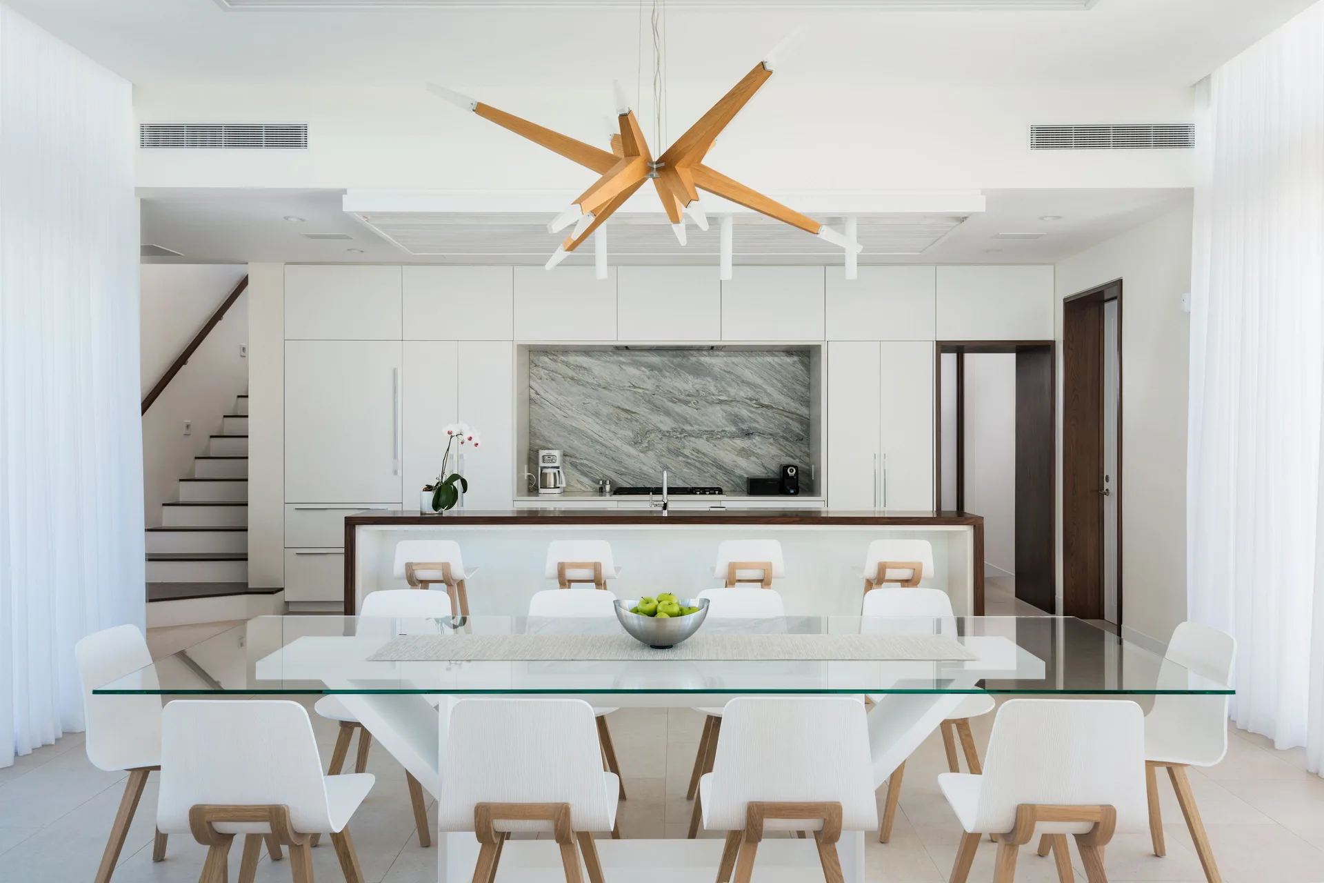 Villa dining table facing a white kitchen at Wymara Resort and Villas.