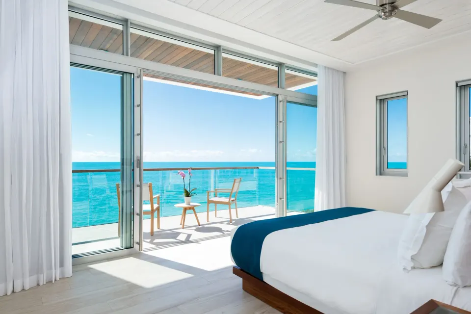 Ocean-view villa bedroom with terrace seating at Wymara Resort and Villas.