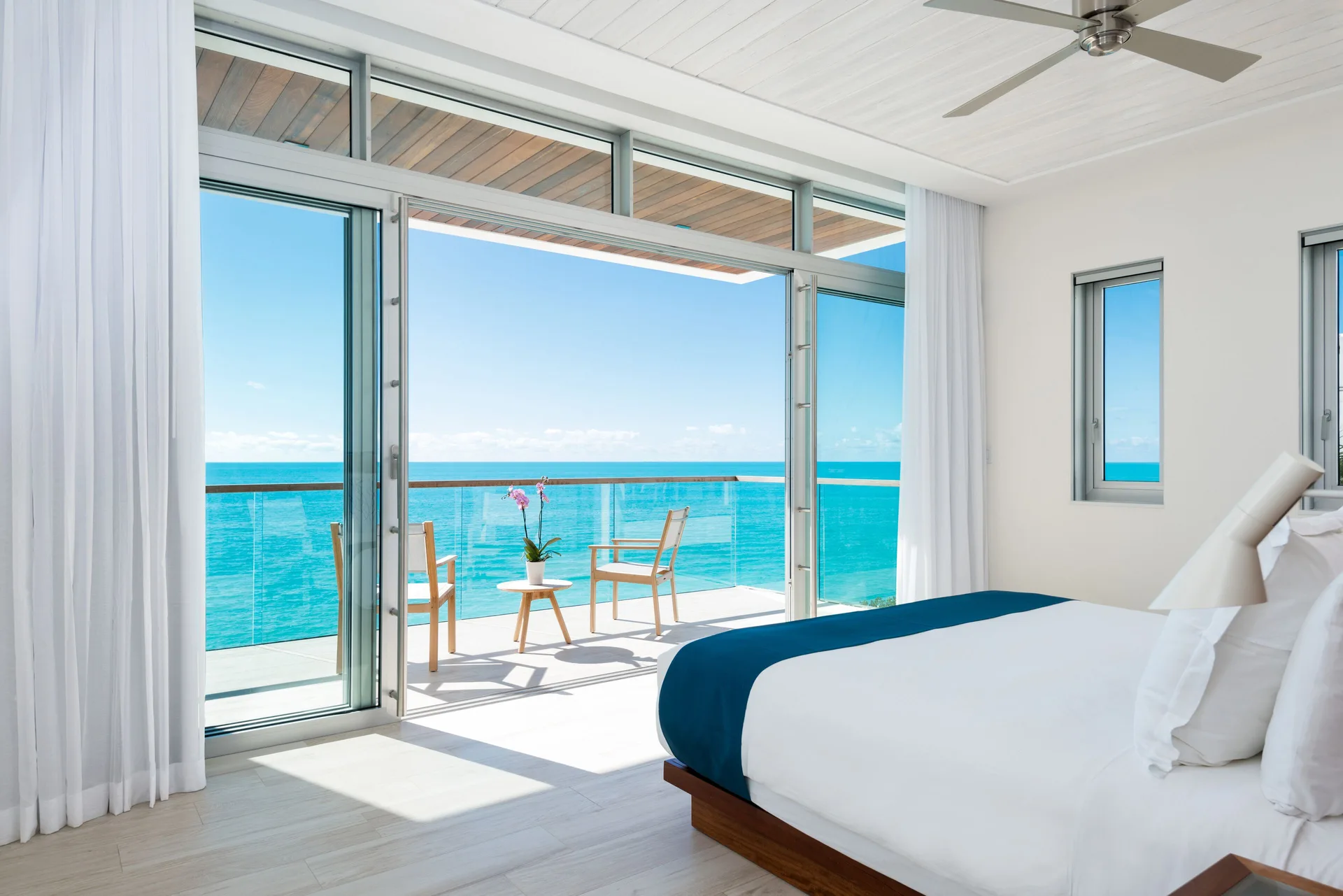 Ocean-view villa bedroom with terrace seating at Wymara Resort and Villas.