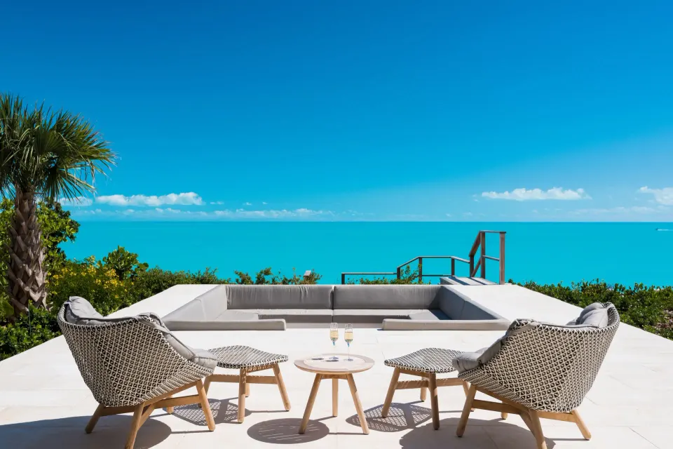 Villa terrace seating overlooking turquoise ocean at Wymara Resort and Villas.